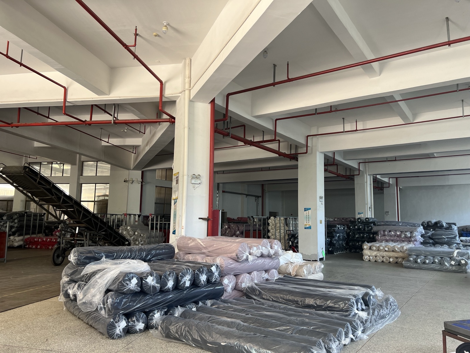 Finished knitted fabric rolls stored by batch inside the factory